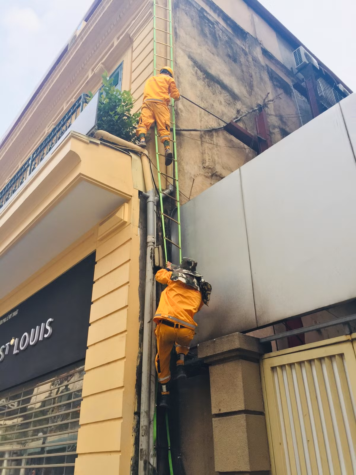 14h chiều cái nắng cũng chẳng đỡ hơn là bao thì cũng là lúc công việc của các anh thợ điện bắt đầu. Nhanh như thoắt hai anh leo thang dây lên lóc của tòa nhà 2 tầng cao lêu nghêu ở khu phố cổ Hà Nội.