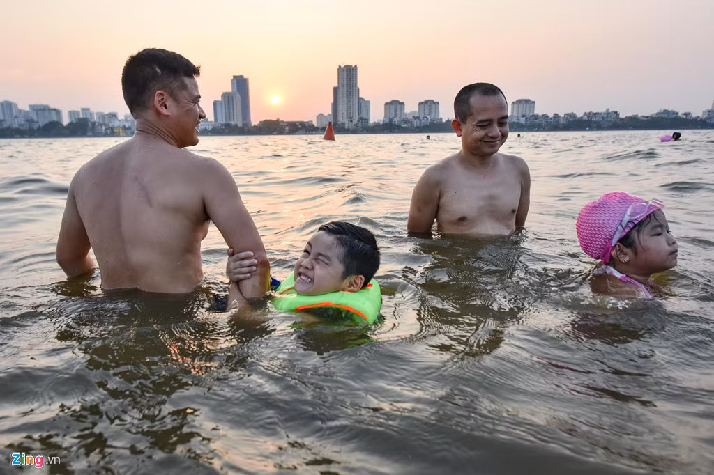 Bé Đạt (trái) bằng tuổi bé Quỳnh Anh, lần đầu được bố đưa ra đây tắm, Đạt rất sợ nước mặc dù đã mặc áo phao.