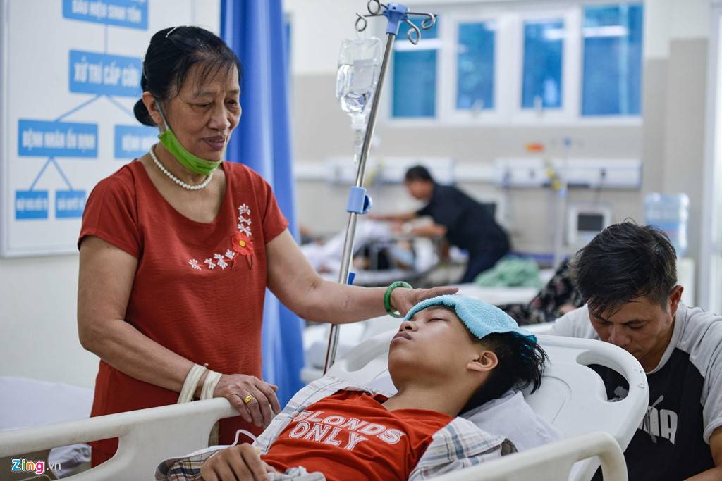 Bà Phạm Kim Tiến (52 tuổi, ở Thanh Nhàn, Hà Nội) đang chăm sóc cháu ngoại bị sốt và ngộ độc, vừa được chuyển vào cấp cứu.