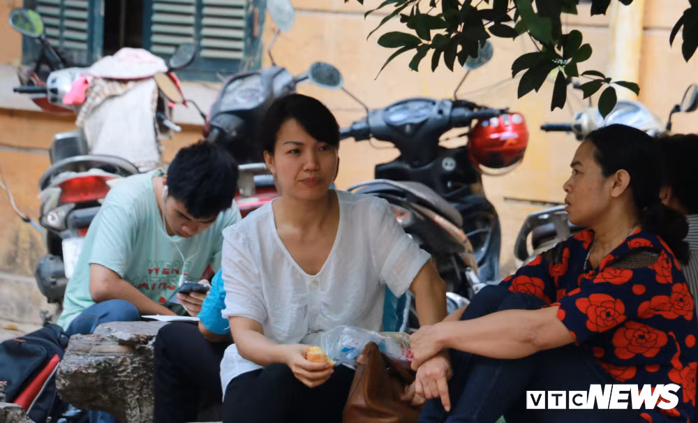 Trong lúc chờ đợi, một phụ huynh tranh thủ ăn sáng. Khuôn mặt lộ rõ sự lo lắng.