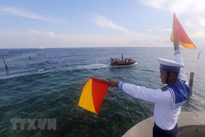 Hướng dẫn cho tàu thuyền vào đảo Đá Đông. (Ảnh: Trần Việt/TTXVN)