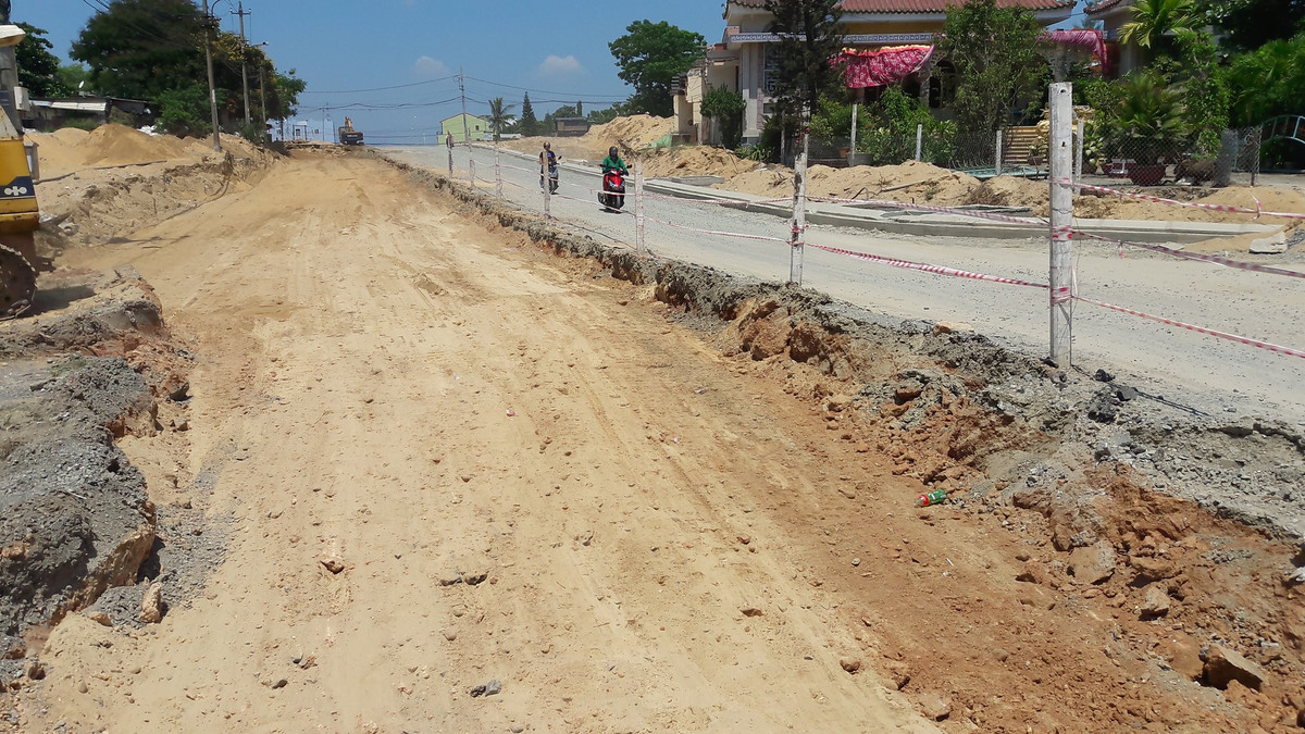 Theo thiết kế, bề rộng con đường 15 m, vỉa hè 5 m, hạ tầng đầy đủ hệ thống điện chiếu sáng, cống thoát nước...Thế nhưng hiện nay, đường được thi công nham nhở, một bên đào sâu, một bên đổ đá dăm. Người dân xung quanh sống ám ảnh vì mùa nắng bụi bay mịt mù, mùa mưa lầy lội.