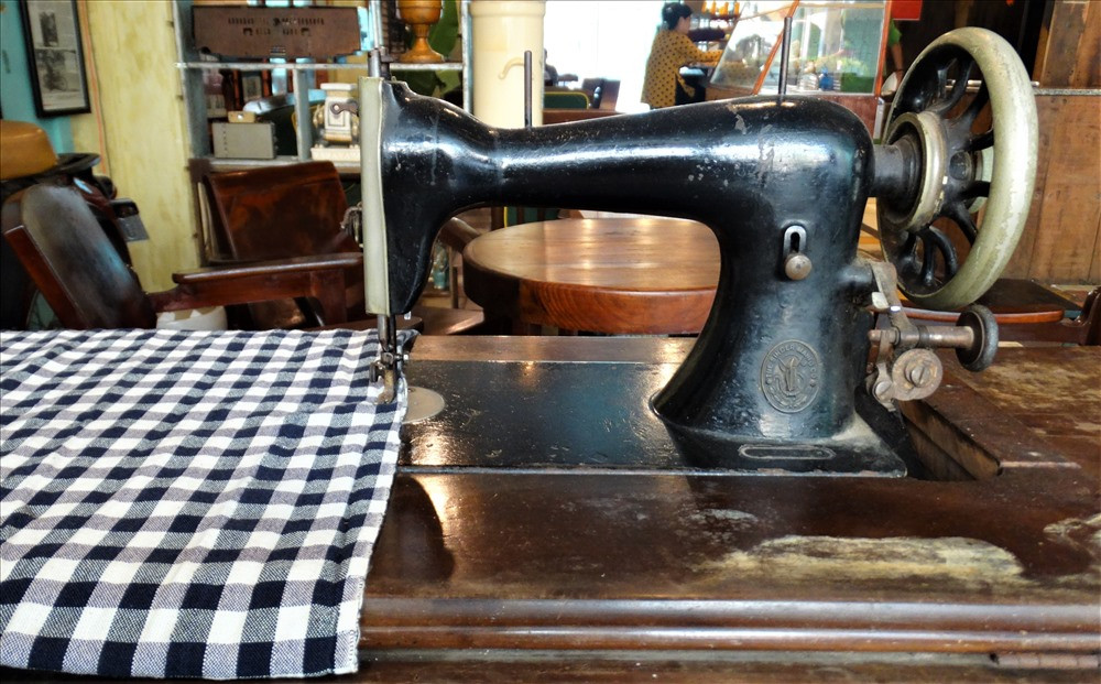 Chiếc máy may hiệu Singer chân kiểu mắc võng có tuổi đời trên 80 năm mà các tiệm may ở Sài Gòn trước đây hay sử dụng được đặt ở bên trái lối vào