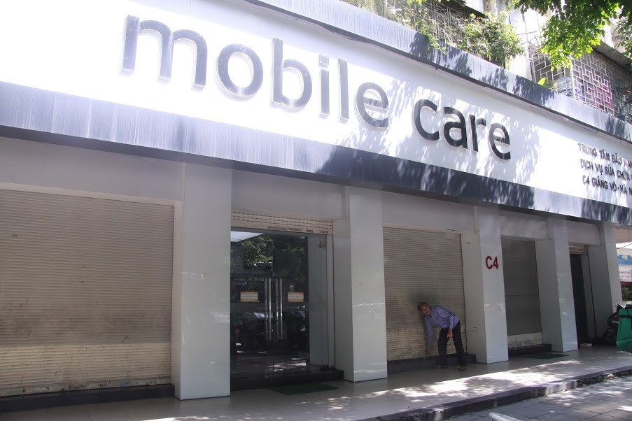 Mặc dù mở cửa, nhưng chỉ một phần cánh cửa chính được mở, đủ để khách hàng ra vào. Toàn bộ cửa kính phía bên ngoài trung tâm bảo hành vẫn bị che kín.