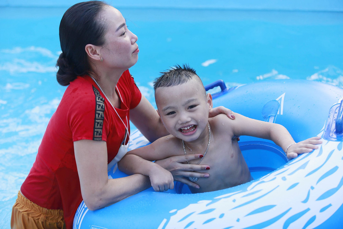 Nụ cười thích thú của một em nhỏ khi được phụ huynh cho đi tắm để "giải nhiệt" ngày nắng nóng.