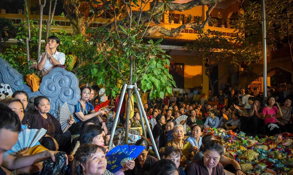 Dù thời tiết oi bức khó chịu nhưng hàng trăm người vẫn nhẫn nại ngồi hành lễ trong sân chùa chật hẹp. 