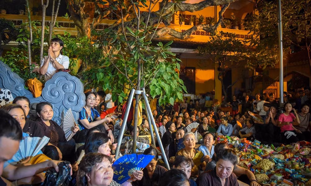 Dù thời tiết oi bức khó chịu nhưng hàng trăm người vẫn nhẫn nại ngồi hành lễ trong sân chùa chật hẹp. 