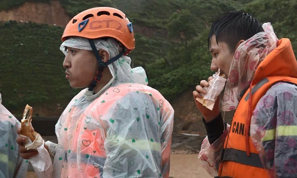 Lực lượng chức năng tranh thủ ăn qua bữa bằng bánh mì trong khi tiếp tục sát cánh cùng bà con Tây Nguyên chống chọi với mưa lũ.