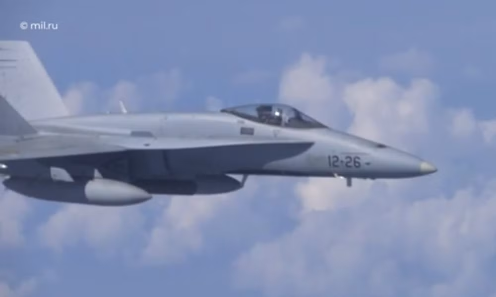 Trong video được ghi lại từ nhìn từ bên trong khoang máy bay của Bộ trưởng Quốc phòng Nga, có thể thấy rất rõ tiêm kích F-18 bay song song theo sau, ở phía bên trái chiếc chuyên cơ. Ảnh: Mil.ru. 