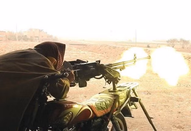 Để tăng tính cơ động và gây bất ngờ cho địch thủ, phe nổi dậy độ chế rất nhiều phiên bản cơ giới gắn súng máy hạng nặng W85 do Trung Quốc sản xuất dựa trên nguyên mẫu DSHK của Liên Xô cỡ đạn 12 Như vậy nó sẽ trở thành hỏa lực cơ giới đa năng vừa có thể tấn công mặt đất hoặc dùng bắn máy bay khi cần. Ảnh: Một khẩu W85 gắn trên xe máy đang khai hỏa vào mục tiêu.