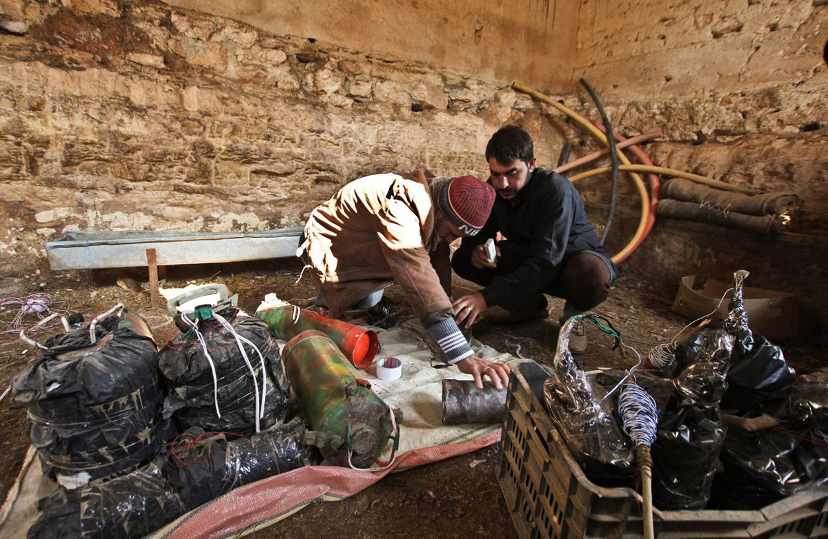 Về mìn tự chế (IED), các chiến binh sản xuất các loại mìn tự tạo làm từ vỏ bình cứu hỏa, bình gas, bình khí nén, hoặc nồi cơm điện. Ảnh: Phiến quân kiểm tra các loại IED dùng để phá hủy xe tải hoặc các thiết bị cơ giới trên đường.