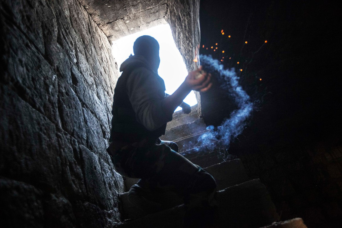 Để tác chiến ở cự ly gần, lựu đạn tự chế dùng để tấn công các đối tượng ẩn nấp trong các căn phòng. Chúng được sử dụng để chứa thuốc nổ và bi sắt, khai hỏa bằng cách đốt dây cháy chậm và ném đi. Ảnh: Một phiến quân chuẩn bị ném lựu đạn tự chế.