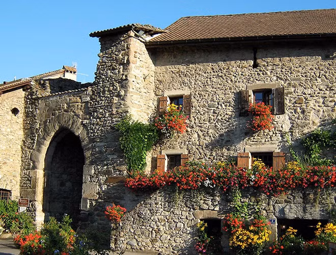 Những ngôi nhà trong làng cổ được xây dựng bằng đá, kết hợp với việc trang trí xung quanh tràn ngập hoa cỏ, tạo nên không gian thoáng mát, dịu nhẹ.