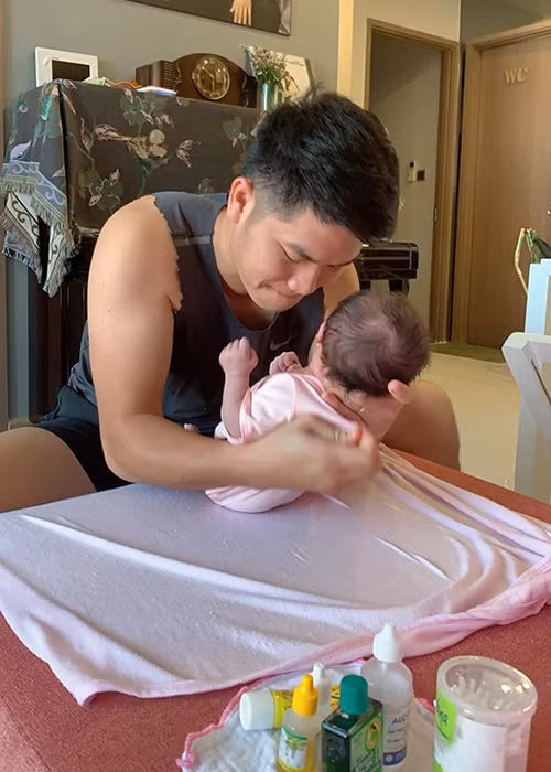 Trung Kiên tự tay tắm gội, thay quần áo, xoa dầu, ru con ngủ.