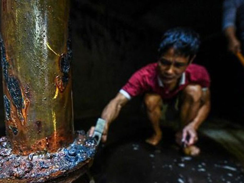 Ông Tạ Hùng, một cư dân tòa nhà khi phối hợp cùng đội công nhân đã phát hiện không khí dưới bể ngầm có mùi khét rất khó chịu, còn nước thì đen kịt. (Ảnh: PV/Vietnam+)