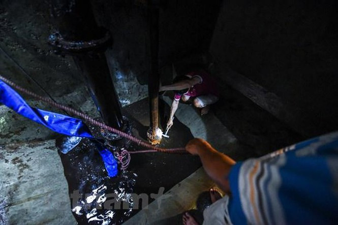 Toàn bộ hơn 200 m3 nước cũ ở bể sẽ được máy bơm công suất lớn hút hết ra ngoài. (Ảnh: PV/Vietnam+)