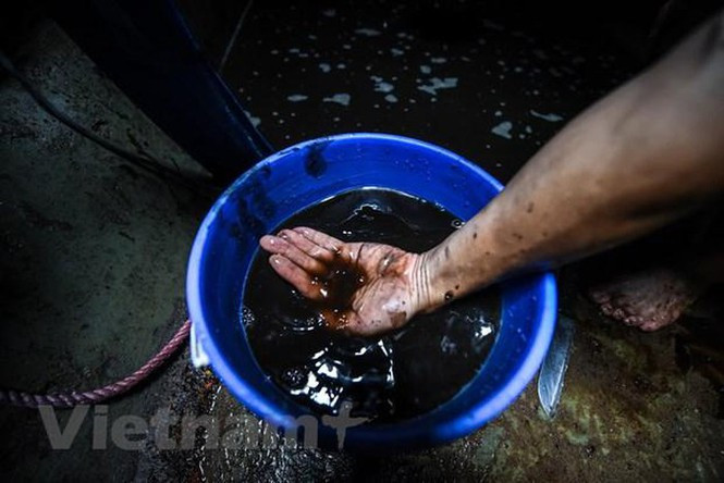 Là thợ sửa xe máy nên ông Hùng biết mùi dưới bể khá giống với mùi dầu thải trong động cơ, còn nước bẩn bắn trên tay ông phải dùng xà phòng rửa nhiều lần vẫn không hết. (Ảnh: PV/Vietnam+)