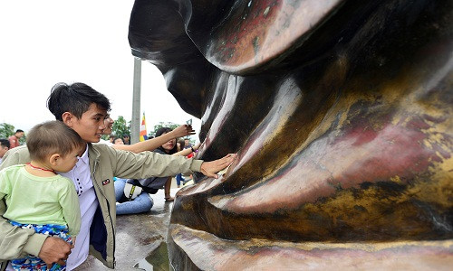 Rất nhiều người dân xoa tiền lên tượng Phật vì quan niệm làm như vậy sẽ gặp nhiều may mắn và tài lộc. Ảnh minh họa: Zing News.