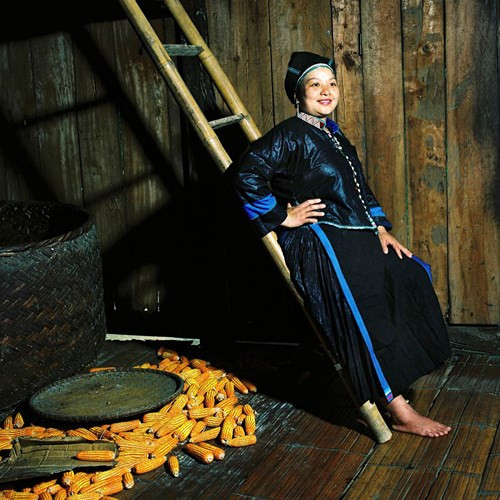 Người phụ nữ Nùng trong trang phục truyền thông, bên trong ngôi nhà sàn – một nét văn hóa đặc trưng khác của người dân vùng miền núi phía Bắc.