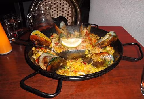 Ẩm thực Cuba phảng phất hương vị Tây Ban Nha, pha lẫn phong cách vùng Caribe. Một bữa ăn đúng kiểu của người dân vùng vịnh này thì các món sẽ được đưa ra cùng lúc chứ không phục vụ từng món như những nước phương Tây. Trong ảnh: Món Paella Habana là loại cơm hơi nhão, đậm mùi nghệ, nấu chung với chem chép, nghêu để cả vỏ, mực, tôm rất hấp dẫn bởi những màu sắc của các loại rau trang trí.