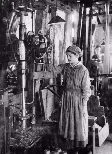 Nữ công nhân vận hành máy móc khi làm việc tại nhà máy sản xuất vũ khí.