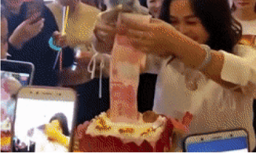 Nữ giám đốc rút mãi mới hết dây tiền từ bánh kem.