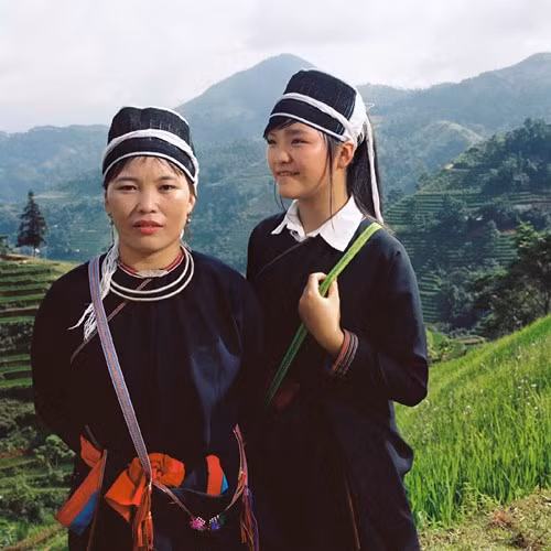 Hai mẹ con người Dao Áo dài trước những khu ruộng bậc thang kỳ vĩ.