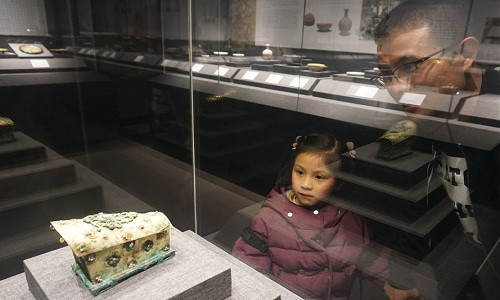 Khách tham quan chiêm ngưỡng cổ vật thời nhà Đường được trưng bày trong tủ kính.