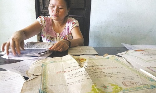 Tấm bằng khen và những giấy tờ khác của chồng đã nhàu nát nhưng chị Thảo vẫn giữ chúng như một ký ức cuối cùng về chồng. Ảnh: NĐT