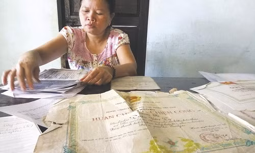 Tấm bằng khen và những giấy tờ khác của chồng đã nhàu nát nhưng chị Thảo vẫn giữ chúng như một ký ức cuối cùng về chồng. Ảnh: NĐT