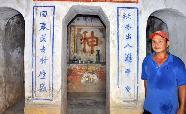 Anh Trần Văn Tủy – người trông coi miếu Ông Cọp đứng bên gian thờ giữa miếu