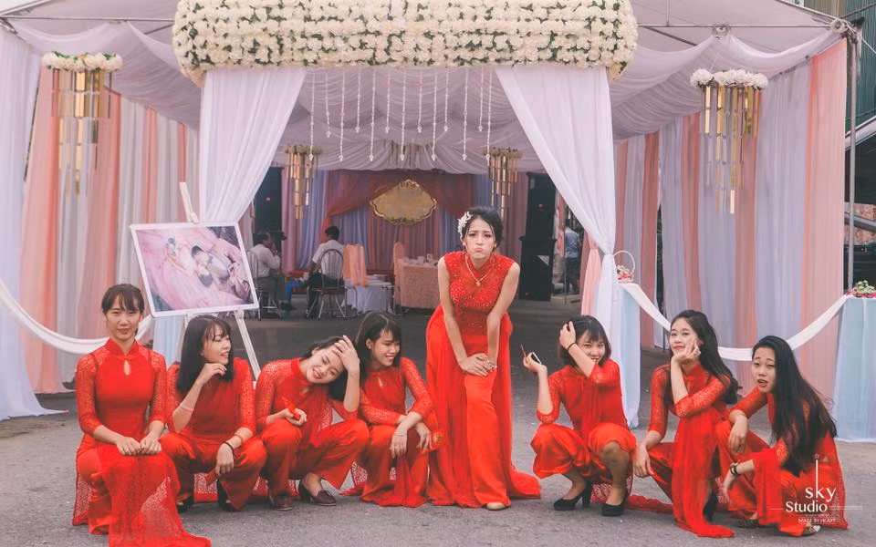 Khác với dáng vẻ dịu dàng, nữ tính vẫn thường thấy của những cô dâu trong ngày hôn lễ, tại đám cưới đặc biệt này, cô dâu và 7 phù dâu trong trang phục áo dài đã không ngại ngần pha trò nghịch ngợm vô cùng dễ thương, khiến mọi người phải bật cười thích thú sau khi xem ảnh. Ảnh trong bài: Cường Nguyễn.