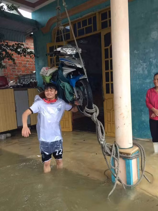 Do nước ngập sâu, nhiều gia đình ở Quảng Bình đã không còn một chỗ trống khô ráo nào để có thể cất giữ đồ đạc. Họ phải dùng dây buộc ròng từ trên trần nhà xuống để treo những đồ vật, của cải có giá trị lên phòng tránh bị nước lũ cuốn trôi, làm hư hại. Ở một số vùng nông thôn, bà con còn sử dụng cách buộc dây này để cứu trâu, bò khỏi bị chết đuối do nước ngập sâu quá đầu. Ảnh: Lê Xuân Trường.