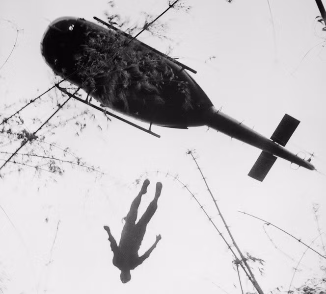 Tử thi của một lính dù Mỹ bị chết trong chiến dịch ở khu rừng già gần biên giới Campuchia (Vùng C) được chuyển đi bằng máy bay trực thăng UH-1, năm 1966. Ảnh:Henri Huet.