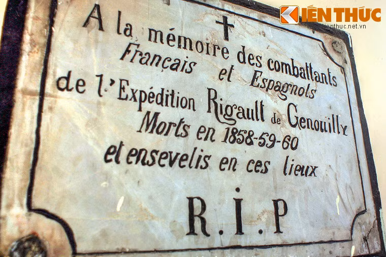 Bức tường bên trái có tấm bia khác dòng chữ “A la mémoire des combattants Francais et Espagnols de l’Expédition Rigault de Genouilly. Mort en 1858 – 59 – 60 et ensevelissement en lieux“. Nghĩa là: "Để tưởng niệm những chiến binh Pháp và Tây Ban Nha của cuộc viễn chinh Rigault de Genuoilly. Chết những năm 1858 – 59 – 60 và được an táng ở đây”.