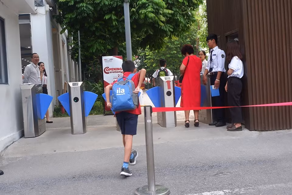 Các học sinh nhanh chân bước vào trường tham dự lễ khai giảng.