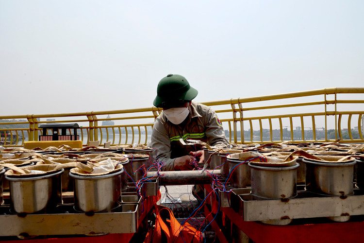 Nhân viên kỹ thuật kết nối dây từng thùng với bảng điều khiển một cách cẩn thận.