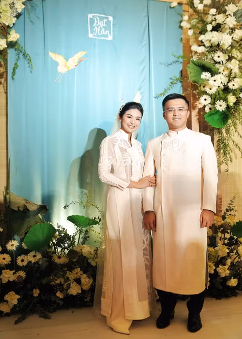 Áo dài cưới của Ngọc Hân tông màu trắng, họa tiết hoa sen. Chú rể cũng diện áo dài trắng. Ảnh: VTV