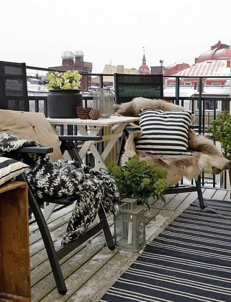 Bàn cà phê bằng gỗ cùng một vài chiếc ghế bằng kim loại, đèn lồng nến và thảm lông tạo sự ấm áp.