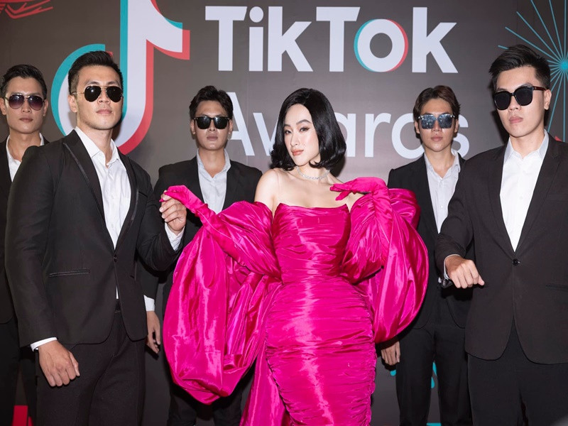 5 vệ sĩ vây quanh Angela Phương Trinh diện vest, đeo kính đen.