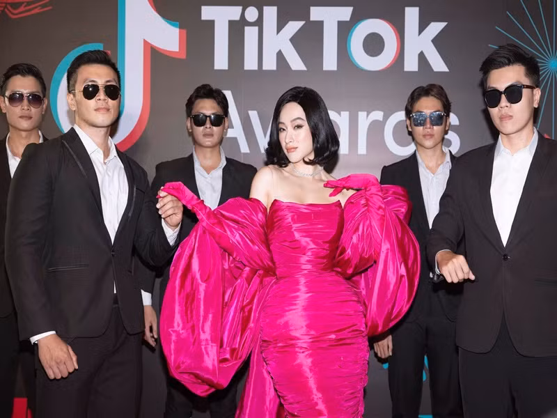 5 vệ sĩ vây quanh Angela Phương Trinh diện vest, đeo kính đen.