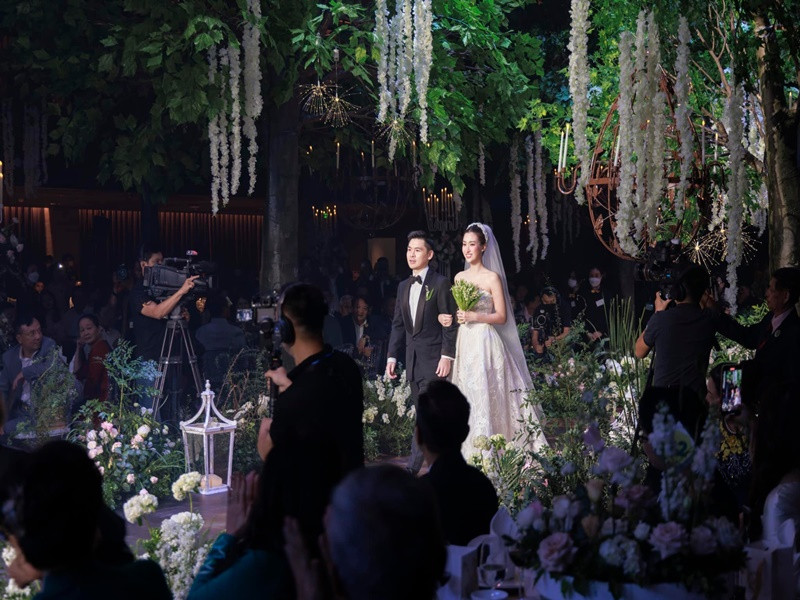 Không gian đám cưới của Đỗ Mỹ Linh được trang hoàng nhiều hoa tươi. Thực đơn đám cưới gồm các món: súp tổ yến, thịt cua bể, salad tổng hợp trộn dầu giấm, tôm hùm Nha Trang bỏ lò, hải sâm hầm gân nai, cá hồi Nauy áp chảo sốt chanh leo, thịt bò Fuji áp chảo sốt tiêu đen, bánh mì Pháp, cơm chiên ngũ sắc, bông cải xanh xào nấm lục ngọc, sốt bào ngư, chè dưỡng nhan tuyết yến. Ảnh: FBNV