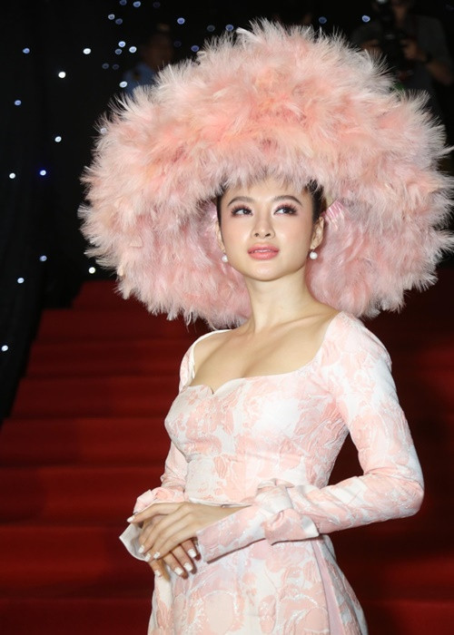 Năm 2018, “bà mẹ nhí” đội chiếc mũ lông chim khổng lồ cùng tông màu với bộ áo dài cách tân khi tham gia một sự kiện. Ảnh: Zing