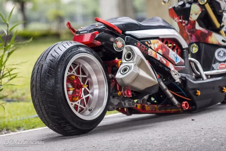 Ở phía sau, chiếc xe được trang bị mâm với bản rộng tới 10 inch. Tuy nhiên do sử dụng lốp cỡ nhỏ hơn mâm 150/70/13 nên lốp xe đã "nở" tròn hơn. Vốn có phanh đùm phía sau, tuy nhiên bản độ này đã nâng cấp lên phanh đĩa với heo Nissin 1 piston. Hệ thống xả trên chiếc Zoomer X này cũng khá độc đáo khi tận dụng lon pô từ Kawasaki Z1000.