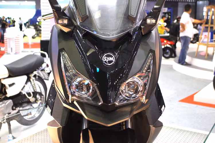 Ở phía trước, cũng giống như MAXSYM 500, CruiSYM 300i cũng sở hữu cặp đèn pha kép với 2 bóng pha dạng thấu kính projector và đèn chiếu sáng ban ngày LED. Tuy nhiên so với MAXSYM, cụm đèn pha của xe đã có thiết kế khá khác biệt với kích thước to hơn, nhưng ít sắc sảo hơn.