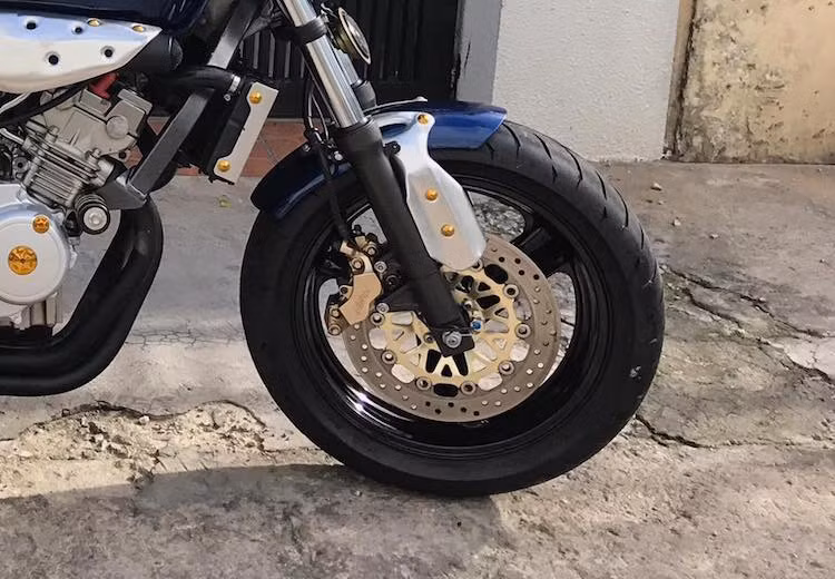 Ngoài ra, xưởng độ LeeAT cũng đã trang bị cho chiếc xe bộ dè trước mới, được gò kết hợp giữa nhôm và tôn theo mẫu của R nine T. Cặp mâm 3 cánh bản lớn kèm hệ thống phanh đĩa trước sau của Hornet 250 nguyên bản không có sự thay đổi.