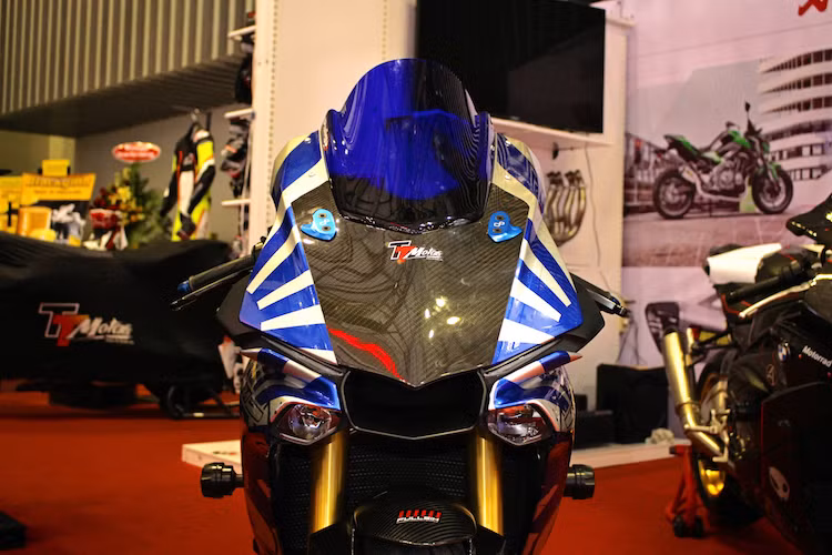 Để khiến chiếc R1M trông giống như một mẫu xe đua WSBK thực thụ, 2 gương chiếu hậu nguyên bản đã được chủ xe loại bỏ, thay vào đó là cặp pad nhôm che của Lightech. Trong khi đó, kính chắn gió trước do Puig cung cấp, với màu xanh chống chói tốt hơn và hạn chế gió tạt ở tốc độ cao.