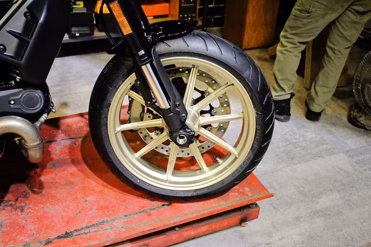 Hệ thống phanh trước sau Brembo và cặp vành 10 nan của phiên bản Scrambler Icon và Full Throttle cũng vẫn được giữ nguyên trên Cafe Racer. Tuy nhiên chiếc xe đã có mâm sơn màu vàng nổi bật hơn, đường kính vành trước hạ từ 18 xuống còn 17 inch và sử dụng lốp trước Pirelli Diablo Rosso II bản 120/70/17 như dòng sportbike 959 Panigale hiện nay.