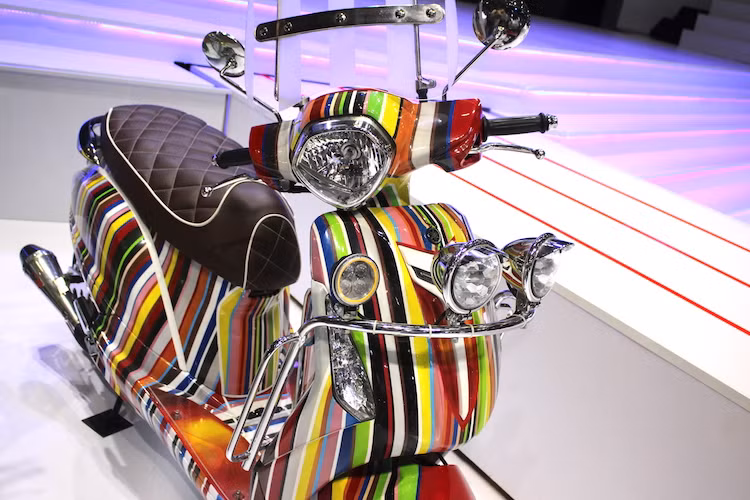 Nguồn cảm hứng để Yamaha tạo ra bản độ này đã được tổng hợp từ nhiều "trường phái" độ khác nhau. Phần thân xe nguyên bản của Grande được giữ nguyên hoàn toàn, tuy nhiên đằng trước chiếc xe đã được trang bị thêm kính chắn gió lớn kèm khung inox gắn một hàng đèn phía trên - những chi tiết theo phong cách Mod quen thuộc với dân chơi Vespa cổ.