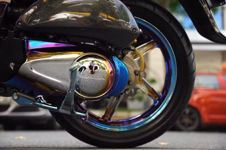 Trong khi đó, các chi tiết kim loại nguyên bản trên xe như bưởng máy, mâm, gắp... đã được sơn mạ theo công nghệ đặc biệt, tạo ra ánh cầu vồng như titan gia nhiệt. Để "ton sur ton" với các chi tiết này, chủ xe đã đầu tư bộ ốc titan thật Proti cho chiếc SH.